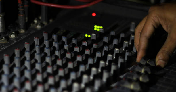 istock hands operating knobs of light and sound board console at a concert theater 989415552