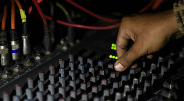 istock hands operating knobs of light and sound board console at a concert theater 989415588