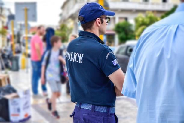 Varna, Bulgaria - May 17 2019: Policeman talking on the phone near his car.