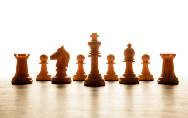 istock wooden white chess pieces lined up in a row on a white background 989456562