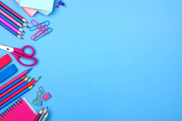 istock Pink and blue school supplies side border over a pastel blue background 989478306