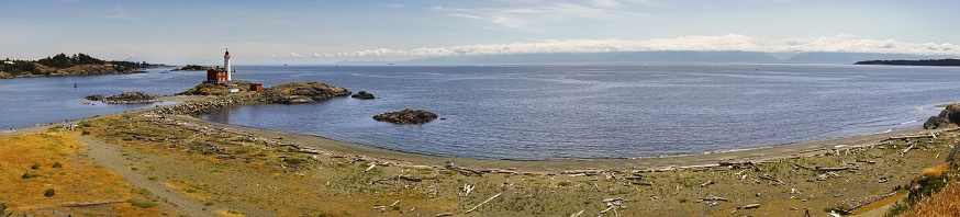 Wide Panoramic Landscape Scenic View of Isolated Fisgard Lighthouse and Distant Juan De Fuca Strait between Vancouver Island and Washington State connecting the Puget Sound to Pacific Ocean