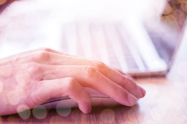 istock Close-Up Of Cropped Hand Using Laptop On Desk 989488536