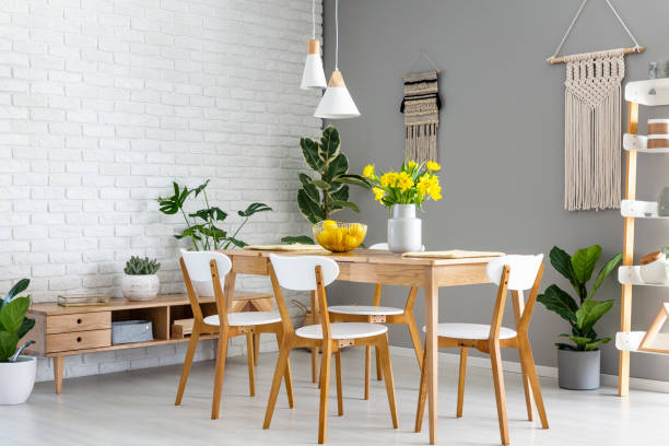 white lamps above wooden table and chairs in dining room interior with yellow flowers. real photo - wall flower sunny temperate flower imagens e fotografias de stock