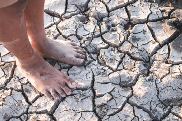 istock Low Section Of Person Standing On Barren Field 989495680