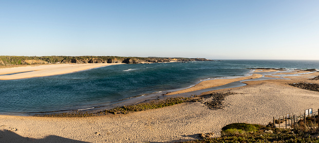 The beach at Vila Nova de Milfontes looking over the mouth of the Mira River towards Furnas Beach, also known as Praia das Furnas, in Portugal