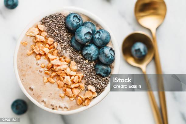 Top View Of Sa Moothie Bowl With Fresh Ripe Blueberry Nuts Chia Banana And Soya Milk Over White Background The Concept Of Healthy Eating And Vegetarian Food Stock Photo - Download Image Now