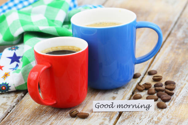 istock Good morning card with two colorful mugs of coffee on rustic surface 989530056
