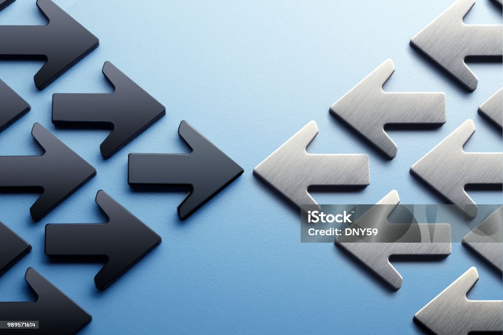 Arrows Pointing Toward A Confrontation Two groups of arrows, one black and one silver, face off against each other. Conflict Stock Photo