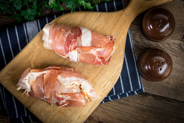 istock Raw chicken breast stuffed with champignon wrapped with bacon. 989582636