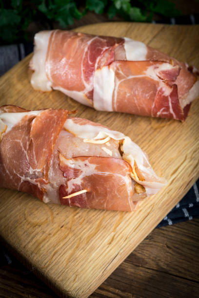istock Raw chicken breast stuffed with champignon wrapped with bacon. 989584676