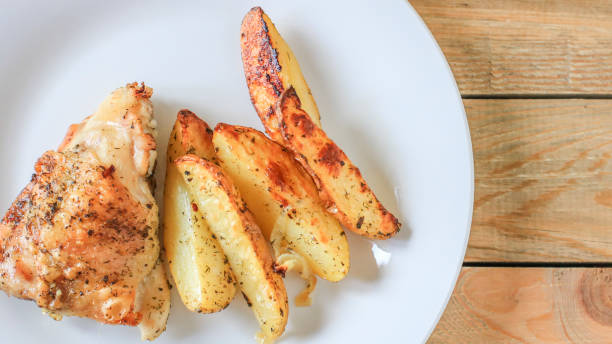 istock Fried potatoes with chicken with golden crust on a white plate 989597998