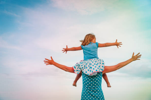 istock mother and little daughter play at sky 989654276