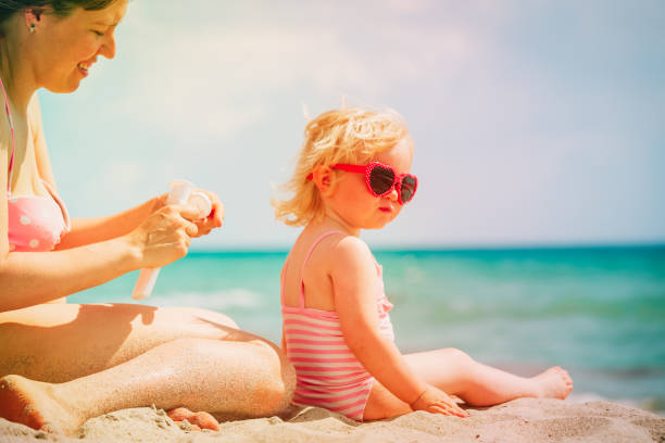 istock mother applying sunblock cream on daughter shoulder 989654530