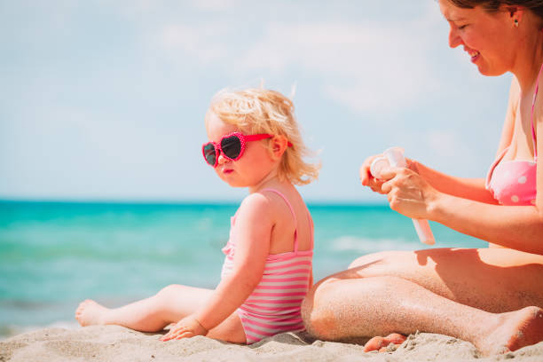 istock mother applying sunblock cream on daughter shoulder 989654592