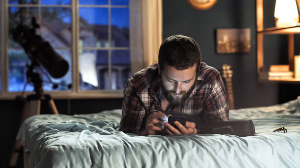 istock Young men surfing smartphone on bed 989659702