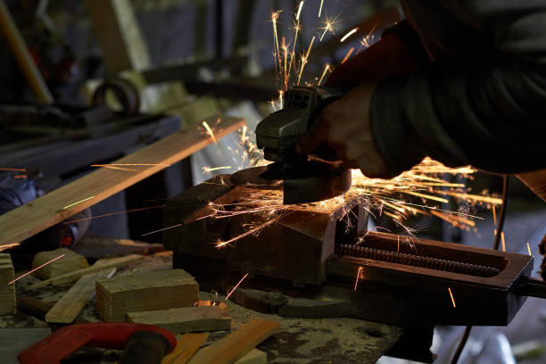 istock Worker Processes the iron part of the grinding machine, the sparks fly in different directions 989668886
