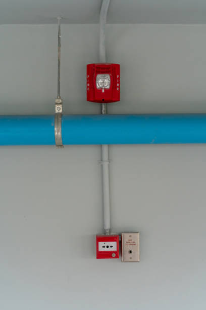 istock Red Fire alarm lighting above blue PVC pipe against white background 989671510