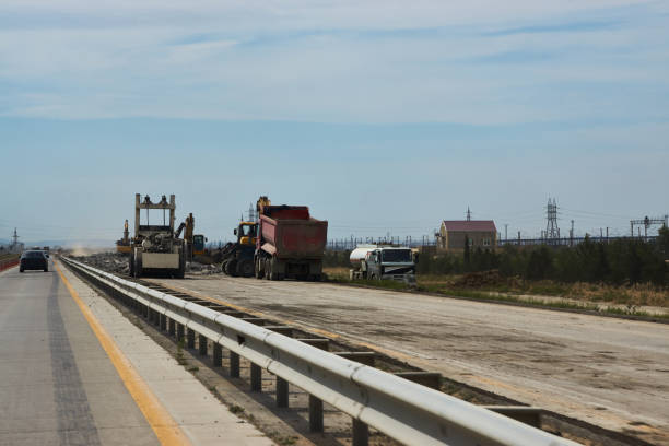 istock New Road Construction with asphalting machines 989704170