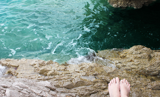 little girl feet on a rocky beach