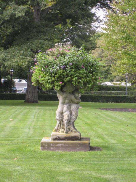 Paris Luxembourg Gardens, there is a circular flower bed and girl statue on the grass land. 