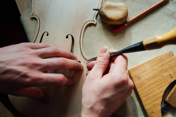 luthier artesano maestro trabajando en la creación de un violín. arduo trabajo en la madera - making craftsperson italian music musical instrument fotografías e imágenes de stock