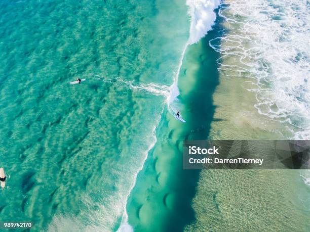 An Aerial View Of Surfers Waiting On The Surfboard For A Wave At The Beach Stock Photo - Download Image Now