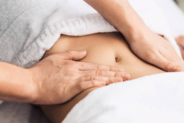 massage des magens im spa. kosmetische klinik, spa, wellness-center, medizinisches konzept. - abdomen women massaging human hand stock-fotos und bilder