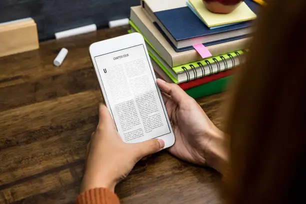 Student reading electronic book from portable digital tablet at the table