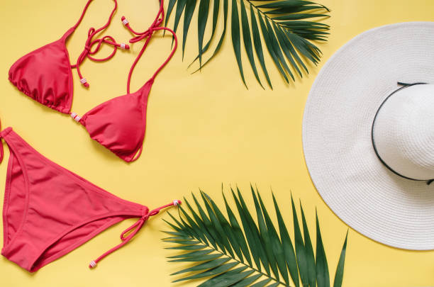 istock Beach apparel and tropical palm leaves arranged on yellow background 989801436
