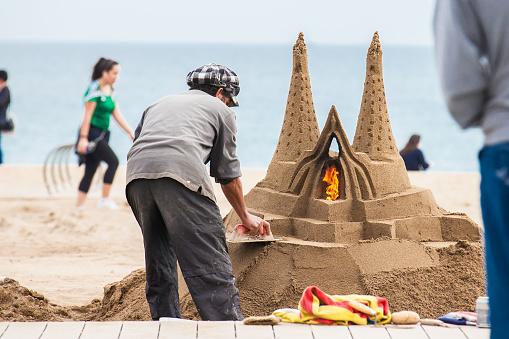 BARCELONA - MARCH, 2018: Sand sculptor working at La Barceloneta Beach in Barcelona Spain