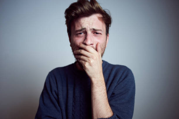 Young sleepy frustrated male teenager yawning alone in the studio. Real people emotions, tiredness, exhausted Young sleepy frustrated male teenager yawning alone in the studio. Real people emotions, tiredness, exhausted man crying stock pictures, royalty-free photos & images