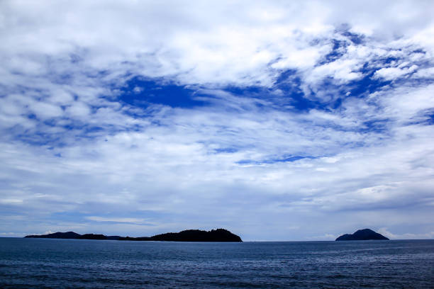 istock Mountains in the sea and clouds on the blue sky 989860536