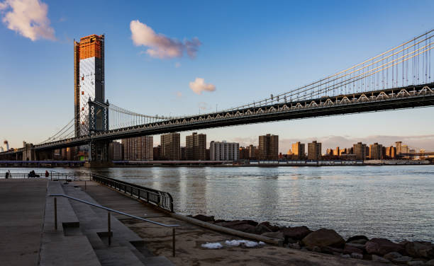 istock Manhattan Bridge, as seen from Dumbo Park in late evening with a few puffy clouds 989921290