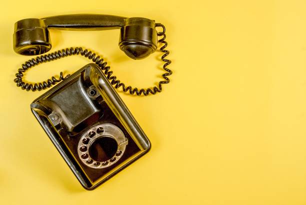 istock Vintage black telephone on yellow 989972434