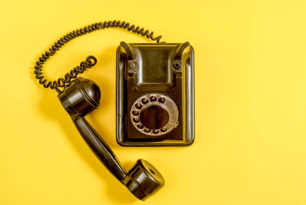 istock Vintage black telephone on yellow 989972438