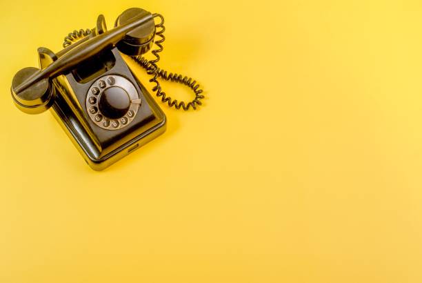 istock Vintage black telephone on yellow 989972440