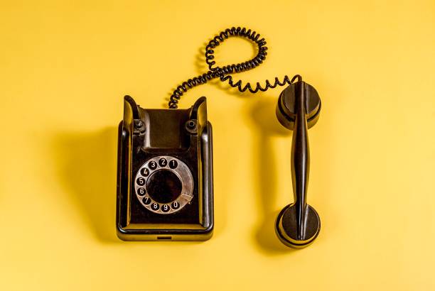 istock Vintage black telephone on yellow 989972446