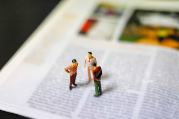 istock Miniature people : journalists , businessman ,suit at work 989984922
