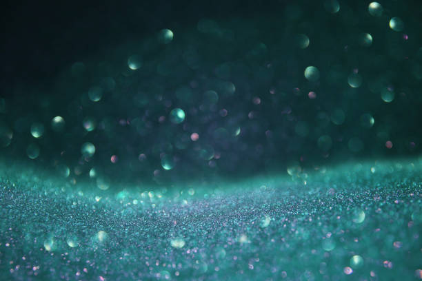 istock glitter vintage lights background. green, mint and black. de-focused. 989993032