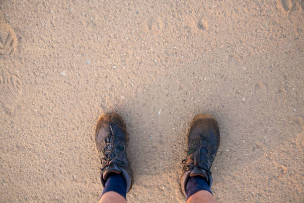 istock hiking boots on man stading on sand 990000622