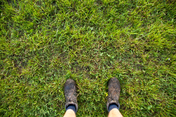 istock hiking boots on man stading on green grass 990000930