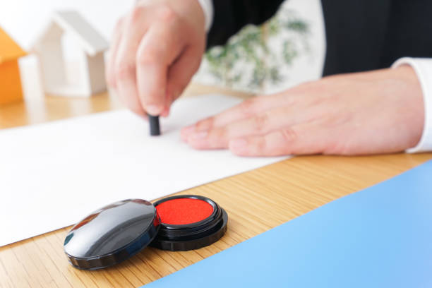 Businessman carefully stamps a document at his desk, showing the world of business and paperwork. His hand in a suit symbolizes precision and control in finance, accounting, and law