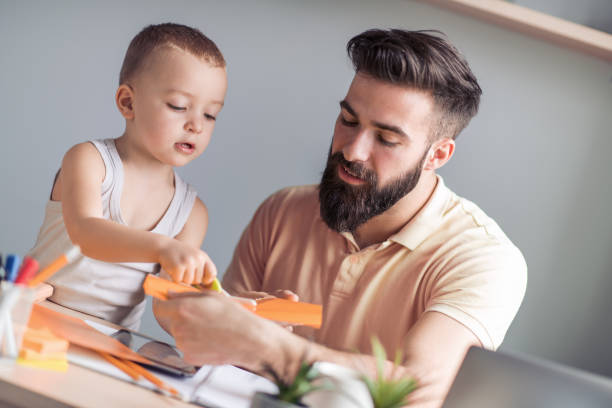 istock Young man working from home and playing with his son 990050868