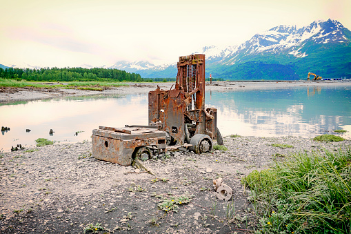An antique forklift sits amongst the glorious beauty of Alaska’s scenic landscape. Located beside the bay in Valdez, Alaska, this forklifts stands as a reminder of days gone by. This area marks the old townsite before the Great Earthquake of 1964.