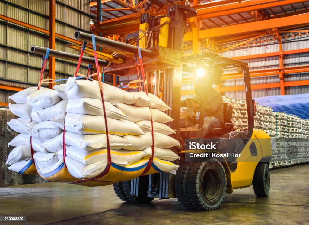 Forklift handling sugar bags for stuffing into container for export. Distribution, Logistics Import Export, Warehouse operation, Trading, Shipment, Delivery concept. Material Stock Photo