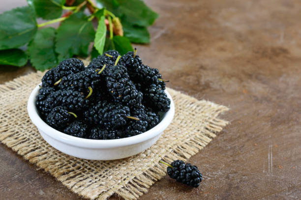 istock Ripe black mulberry in a bowl. Close-up. 990091784