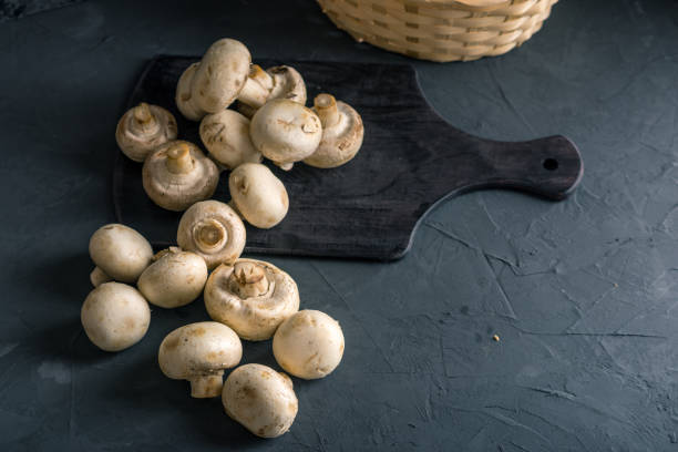 istock Champignons on the dark kitchen table. Cooking delicious dishes with mushrooms 990104638