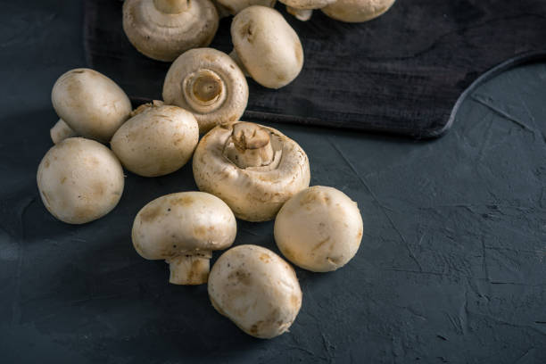 istock Champignons on the dark kitchen table. Cooking delicious dishes with mushrooms 990104646