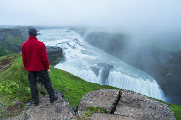 istock Tourist looks at the Gullfoss waterfall in Iceland 990118514